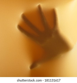abstract hands, human arm inside yellow fabric, studio shot