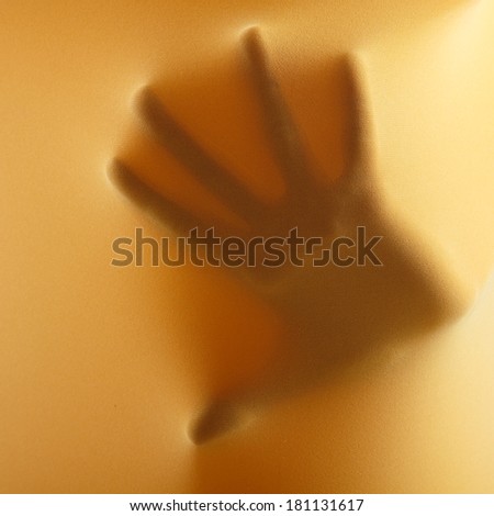 abstract hands, human arm inside yellow fabric, studio shot