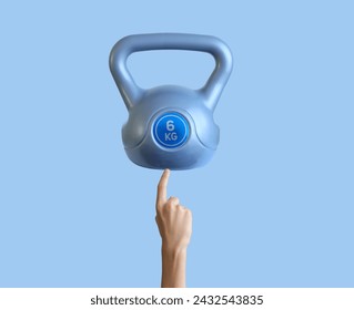 Abstract healthy concept, Closeup Hand pointing finger to kettlebell isolated on blue background, concept of healthy lifestyle - Powered by Shutterstock