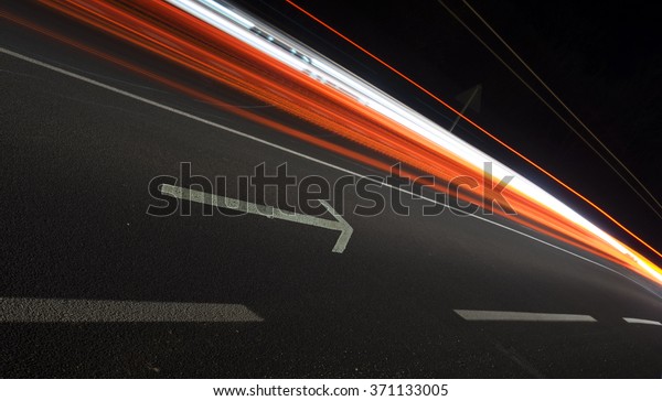 Abstract\
image, arrow and car lights trails at\
night.