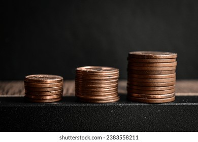 An abstract image or background of some stacks of European copper pennies or nickles on top of a wooden table symbolizing economical growth