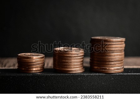 An abstract image or background of some stacks of European copper pennies or nickles on top of a wooden table symbolizing economical growth