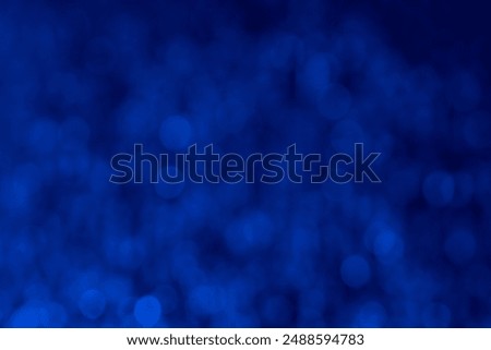 An abstract image with a blurred bokeh effect in blue tones, creating a soft and dreamy atmosphere. Soft selective focus. Artificially created image grain. Atmospheric distortion.