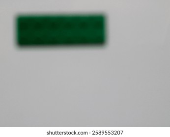 Abstract image of a blurred green rectangular object against a clean white background, showcasing minimalism and simplicity.