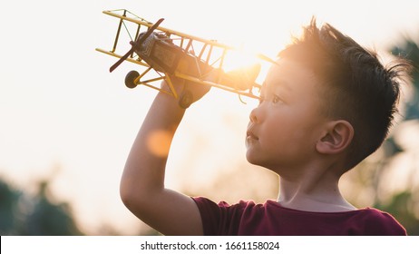 the abstract image of the boy holds an airplane model overlay with sunlight. the concept of educations, future, business, international and travel.