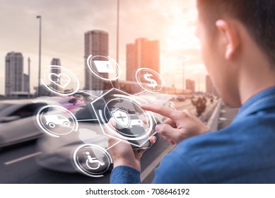 The abstract image of business man point to the hologram on his smartphone and blurred traffic is backdrop. the concept of communication, network, insurance, financial and internet of things. - Powered by Shutterstock