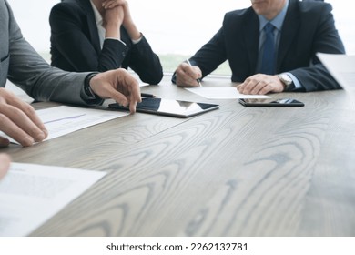 Abstract Image of business people meeting at office table with smart phone and digital tablet and coworkers working in the background - Shutterstock ID 2262132781