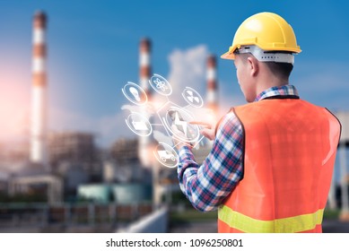 The abstract image of the engineer holding smartphone with hologram and the blurred power plant is backdrop. the concept of clean energy, futuristic, industrial4.0 and internet of things.