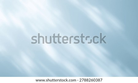 An abstract image featuring light and shadow patterns on a blue background, creating a sense of depth and movement. The soft, diffused light adds a dreamy quality.