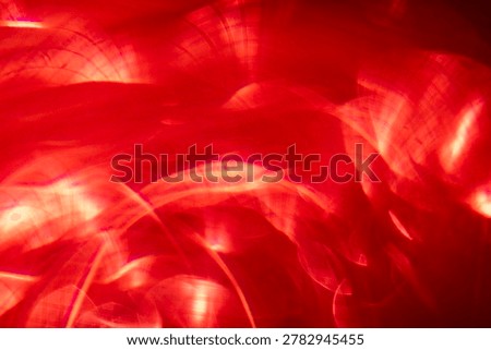 Abstract image featuring red light patterns and blurred shapes, creating a vibrant and dynamic visual effect for use in backgrounds or artistic projects