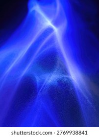 An abstract image featuring swirling patterns of bright blue light against a dark background, creating a sense of energy and movement.