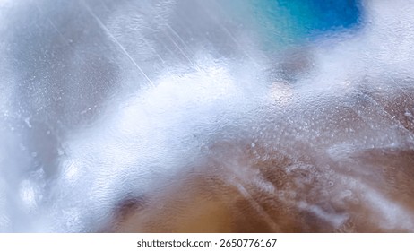 Abstract image featuring water droplets and blurred colors creating a textured, ethereal effect.