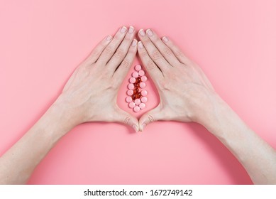 abstract image of female genital organs from hands and pills. concept of women's health and the treatment of female diseases of the urinary tract
