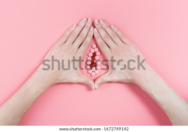 abstract image of female genital organs from hands\
and pills. concept of women\'s health and the treatment of female\
diseases of the urinary\
tract