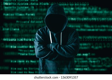 The abstract image of the hacker standing and the binary code image is backdrop. the concept of cyber attack, virus, malware, illegally and cyber security. - Shutterstock ID 1363091357
