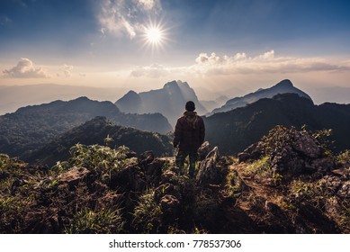 The abstract image of the hiker standing on the cliff for looking to the sun and layer of mountains. Doi luang chiang dao, Chiang dao national park, Chiang mai, Thailand.