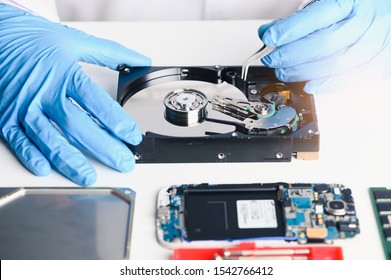 The abstract image of inside of hard disk drive on the technician's desk and a computer motherboard as a component. the concept of data, hardware, and information technology.