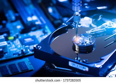 La imagen abstracta del interior de la unidad de disco duro en el escritorio del técnico y una motherboard de computadora como componente. el concepto de datos, hardware y tecnología de la información.