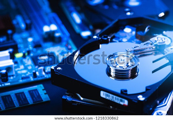 The abstract\
image of inside of hard disk drive on the technician\'s desk and a\
computer motherboard as a component. the concept of data, hardware,\
and information technology.