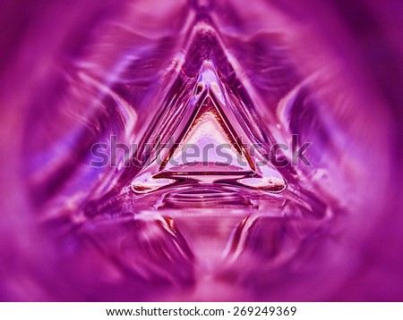 Abstract image of the inside of a triangle glass bottle hot pink color background