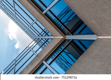 Abstract image of looking up at modern glass and concrete building. Architectural exterior detail of industrial office building. Industrial art and detail.