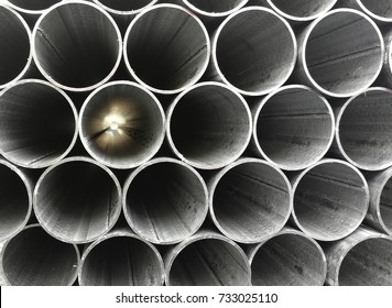 Abstract image of metal pipes showing light on the other end. Background texture.