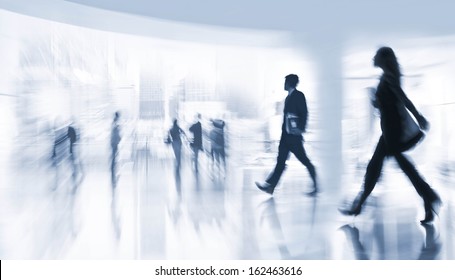 abstract image of people in the lobby of a modern business center with a blurred background  and a blue tonality