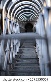 Abstract image of a repeating pattern of metal arches, creating a sense of depth and perspective.