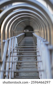 Abstract image of a repeating pattern of metal arches, creating a sense of depth and perspective.