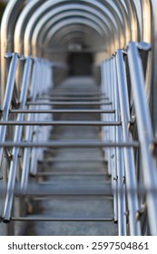 Abstract image of a repeating pattern of metal arches, creating a sense of depth and perspective.