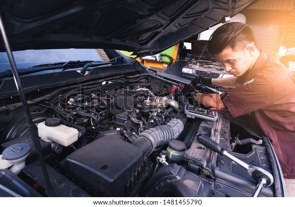 The abstract image of\
the technician using voltage meter for voltage measurement a car\'s\
battery. the concept of automotive, repairing, mechanical, vehicle\
and technology.