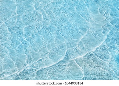Abstract image of top view of shiny wave of clear blue sea water over sand beach, for beautiful background decoration of summer time