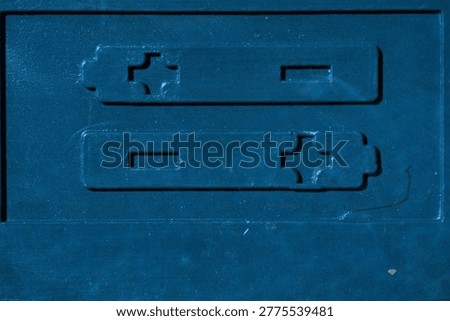 An abstract image of the underside of a AAA battery container cover, indicating the correct positioning of the batteries                              