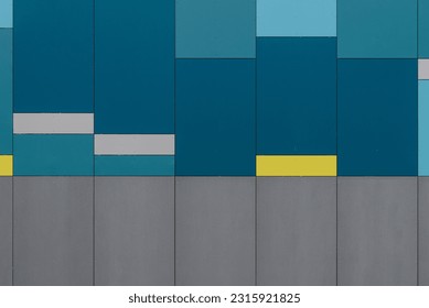 Abstract image of a wall with colorful rectangular plates in shades of blue, with gray and yellow areas.