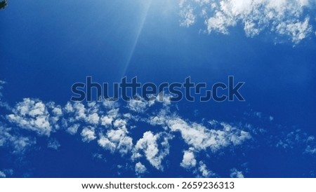 abstract image of white clouds on a bright blue sky with sunlight