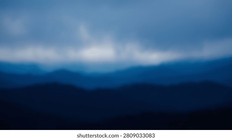 An abstract, impressionistic view of layered blue mountains under a dramatic sky filled with clouds and a bright horizon.