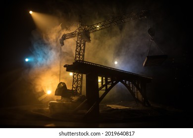 Abstract Industrial background with construction crane silhouette over amazing night sky with fog and backlight. Tower crane against the foggy sky at night. Industrial skyline. Selective focus - Powered by Shutterstock