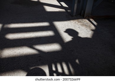 Abstract industrial background. Shadow of stair and worker on textured concrete. Bright sunlight.