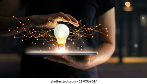 Abstract. Innovation. Hands holding tablet with light bulb future technologies and network connection on virtual interface background, innovative technology in science and communication concept 
