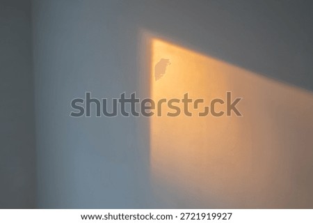 Abstract interior light play showcasing a broad, atmospheric golden ray of light stretching across a dark, matte surface. This image captures the essence of the 