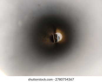 Abstract interior view from inside a circular pipe tunnel showing bright light at the end with soft gradient shadows and industrial texture.