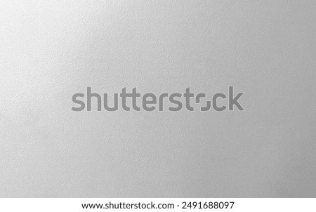 Abstract light gray silver texture background with a brushed metal effect, featuring a rough, grungy grain texture. It resembles stainless steel, perfect for a sleek, industrial look.