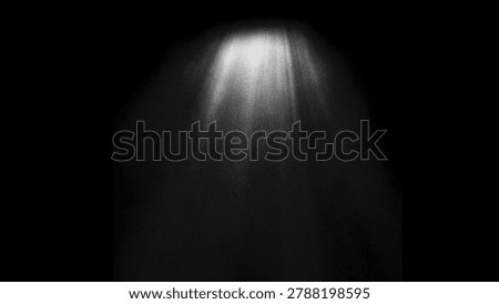 Abstract light rays shining down from above in a dark, grainy atmosphere with a spotlight effect
