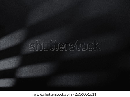 Abstract light and shadow composition on a black paper background. Rectangular and softly blurred light shapes appear to be cast through a gridded surface or blinds.