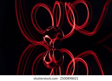 Abstract Light Trails and Glass Reflection in Motion - Dynamic Red Loops Against Black Background