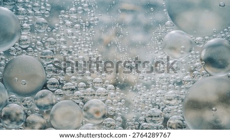 Abstract liquid surface displaying clear oil droplets suspended in water, creating a captivating light texture and pattern. Photography, no generative ai