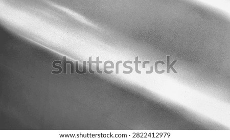 Abstract macro background texture of smooth silver grey metallic surface with soft horizontal light reflection