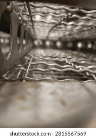 Abstract macro and perspective view inside stacked stainless steel industrial wire mesh trays with shallow depth of field.