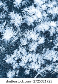 Abstract macro texture of large ice crystals and hoarfrost on a dark surface, beautiful winter rime patterns with sharp frozen details