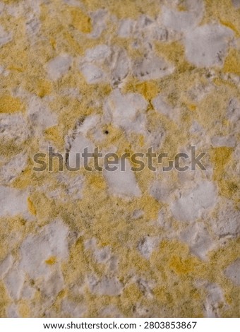Abstract macro texture of yellow and white bonded foam padding background.